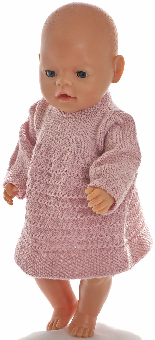 Knit in the round or on two needles, this charming pink dress features beautiful stitch detailing and long sleeves for cooler evenings.
The sleeves are long for cool evenings. The dress is buttoned at the top of the back.